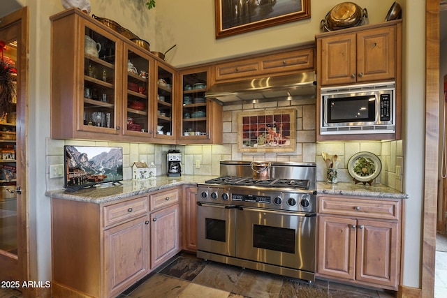 2800 E Morning Glory Cir, Payson, AZ 85541 - kitchen featuring appliances with stainless steel finishes, under cabinet range hood, tasteful backsplash, light stone countertops, and glass insert cabinets