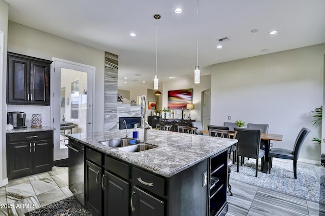 6215 E Sefton Dr, Prescott Valley, AZ 86314 - kitchen featuring light stone counters, a sink, a center island with sink, visible vents, and decorative light fixtures