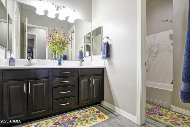 6215 E Sefton Dr, Prescott Valley, AZ 86314 - bathroom featuring a bath, baseboards, double vanity, wood finished floors, and a sink