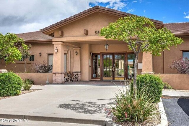 6215 E Sefton Dr, Prescott Valley, AZ 86314 - view of exterior entry with french doors, a tiled roof, and stucco siding