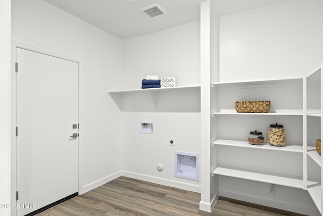 clothes washing area featuring electric dryer hookup, hardwood / wood-style floors, hookup for a gas dryer, and hookup for a washing machine