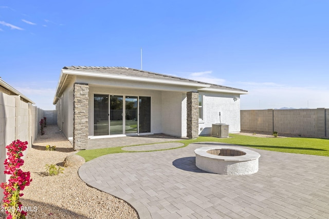 rear view of house with a patio and an outdoor fire pit