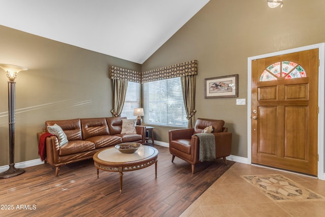 living area featuring baseboards, a wealth of natural light, and high vaulted ceiling