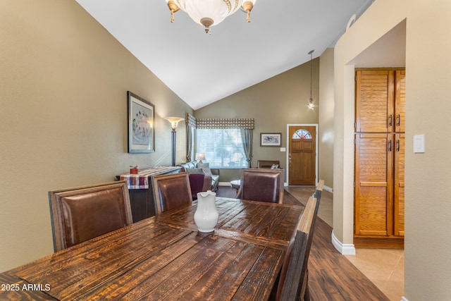 dining room with baseboards, high vaulted ceiling, and wood finished floors