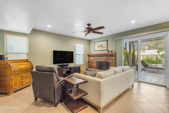 living area with ceiling fan, plenty of natural light, and light tile patterned flooring