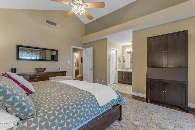 bedroom featuring a sink, baseboards, wood finished floors, ensuite bathroom, and visible vents