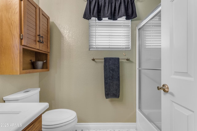 full bathroom featuring vanity, enclosed tub / shower combo, a textured wall, and toilet