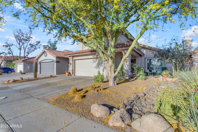 mediterranean / spanish house featuring a garage, stucco siding, a tiled roof, and driveway