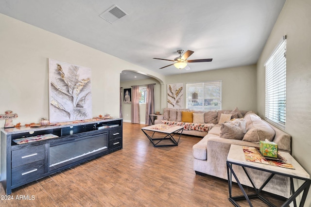 living room featuring dark wood-type flooring and ceiling fan