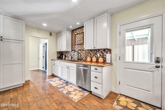 kitchen featuring decorative backsplash, sink, stainless steel dishwasher, white cabinets, and light hardwood / wood-style floors