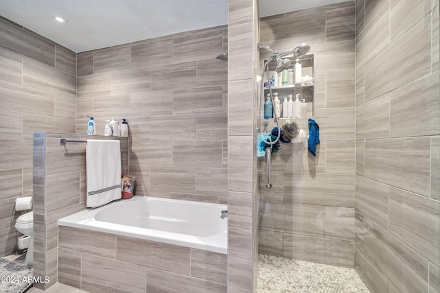 bathroom featuring toilet and shower with separate bathtub