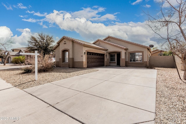 9325 W Elwood St, Tolleson, AZ 85353 - mediterranean / spanish house with an attached garage, stucco siding, concrete driveway, and a tiled roof