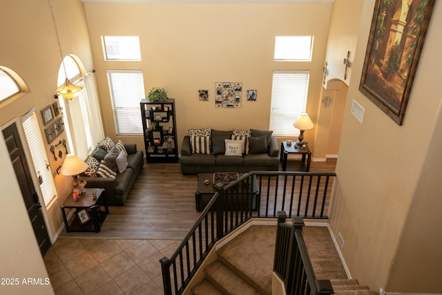 staircase featuring plenty of natural light, a towering ceiling, and tile patterned floors