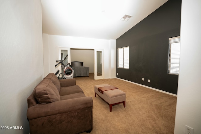 carpeted living room featuring high vaulted ceiling, visible vents, and baseboards