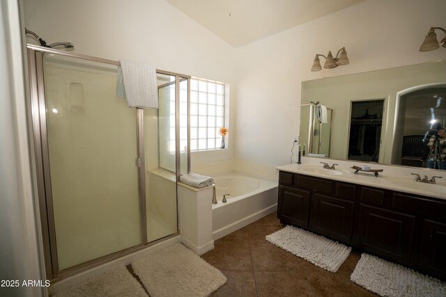 full bath featuring a walk in closet, a garden tub, a sink, and a shower stall