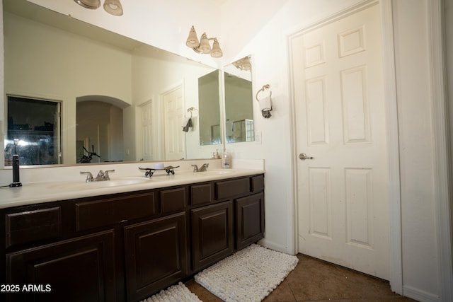 full bath featuring double vanity, a sink, and tile patterned floors