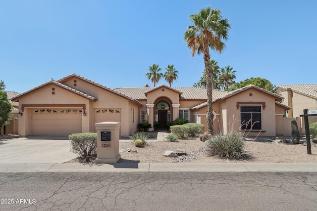 12183 E Mercer Ln, Scottsdale, AZ 85259 - mediterranean / spanish home featuring an attached garage, stucco siding, driveway, and a tile roof