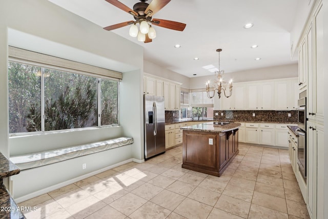 12183 E Mercer Ln, Scottsdale, AZ 85259 - kitchen with stainless steel appliances, backsplash, a chandelier, light tile patterned floors, and decorative light fixtures