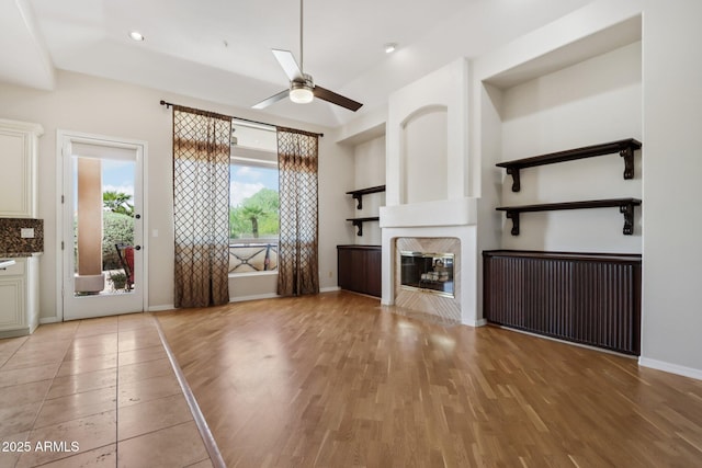 12183 E Mercer Ln, Scottsdale, AZ 85259 - unfurnished living room with a ceiling fan, light wood-type flooring, a high end fireplace, baseboards, and recessed lighting