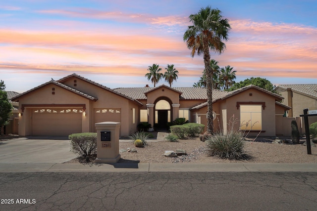 12183 E Mercer Ln, Scottsdale, AZ 85259 - mediterranean / spanish home featuring stucco siding, an attached garage, concrete driveway, and a tile roof