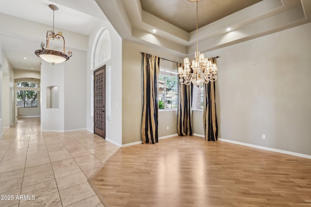 12183 E Mercer Ln, Scottsdale, AZ 85259 - spare room featuring a chandelier, recessed lighting, light wood-style floors, a raised ceiling, and baseboards