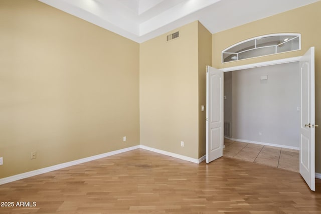12183 E Mercer Ln, Scottsdale, AZ 85259 - unfurnished room with light wood-style flooring, a high ceiling, and baseboards