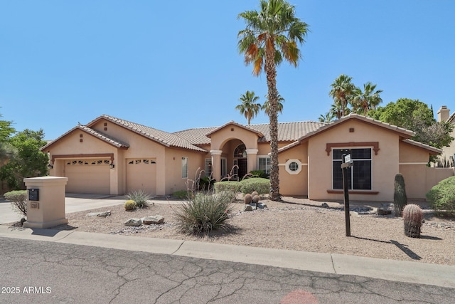 12183 E Mercer Ln, Scottsdale, AZ 85259 - mediterranean / spanish-style home featuring a garage, stucco siding, concrete driveway, and a tiled roof