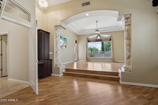 12183 E Mercer Ln, Scottsdale, AZ 85259 - foyer featuring ornate columns, arched walkways, a ceiling fan, light wood-style floors, and a tray ceiling
