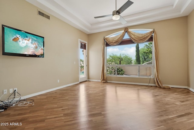 12183 E Mercer Ln, Scottsdale, AZ 85259 - unfurnished room featuring a raised ceiling, ceiling fan, wood finished floors, and baseboards