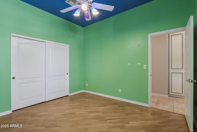 12183 E Mercer Ln, Scottsdale, AZ 85259 - unfurnished bedroom featuring wood finished floors, a closet, baseboards, and a ceiling fan
