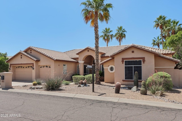 12183 E Mercer Ln, Scottsdale, AZ 85259 - mediterranean / spanish-style home with stucco siding, a garage, a tiled roof, and driveway