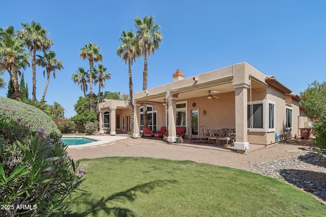 12183 E Mercer Ln, Scottsdale, AZ 85259 - back of property featuring ceiling fan, stucco siding, a chimney, a patio, and a yard