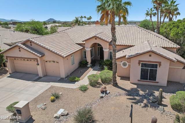 12183 E Mercer Ln, Scottsdale, AZ 85259 - mediterranean / spanish home with stucco siding, a garage, concrete driveway, and a tile roof