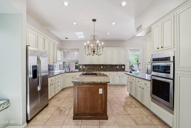 12183 E Mercer Ln, Scottsdale, AZ 85259 - kitchen with appliances with stainless steel finishes, a chandelier, backsplash, a kitchen island, and recessed lighting