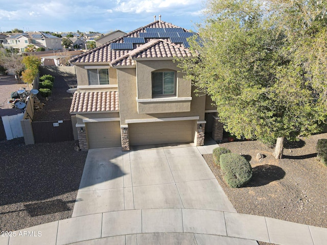 mediterranean / spanish-style home with a garage, stone siding, a tiled roof, and stucco siding