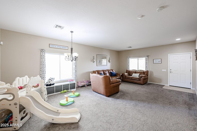 carpeted living room with visible vents and a notable chandelier