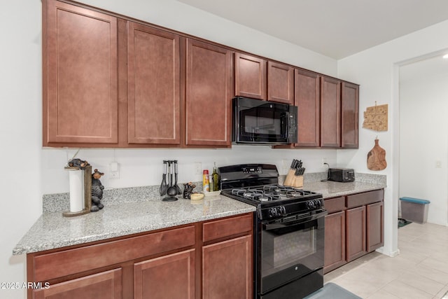 kitchen featuring light stone countertops and black appliances