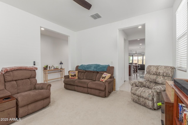 living room featuring light colored carpet and ceiling fan