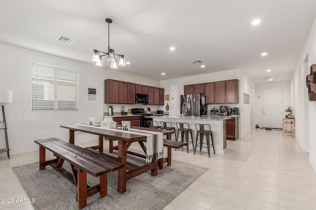 tiled dining room with an inviting chandelier