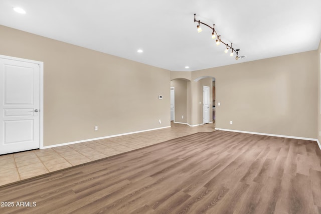 209 E Diamond Trl, San Tan Valley, AZ 85143 - spare room featuring arched walkways, light wood-type flooring, recessed lighting, track lighting, and baseboards
