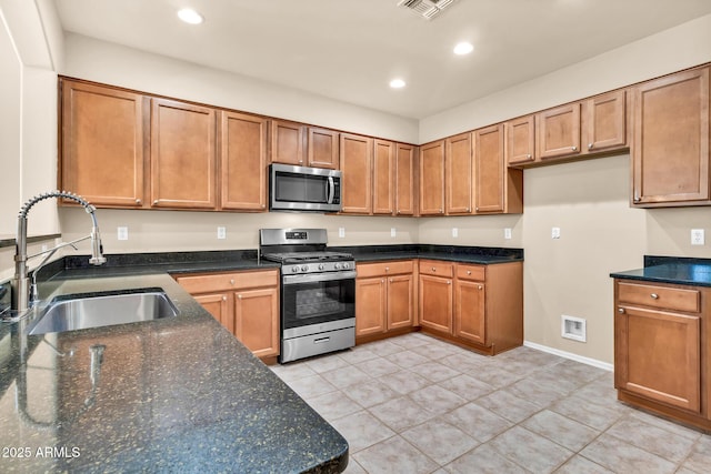 209 E Diamond Trl, San Tan Valley, AZ 85143 - kitchen with stainless steel appliances, a sink, recessed lighting, brown cabinets, and dark stone counters