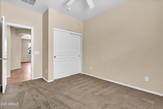 209 E Diamond Trl, San Tan Valley, AZ 85143 - unfurnished bedroom featuring arched walkways, carpet floors, baseboards, tile patterned flooring, and a closet