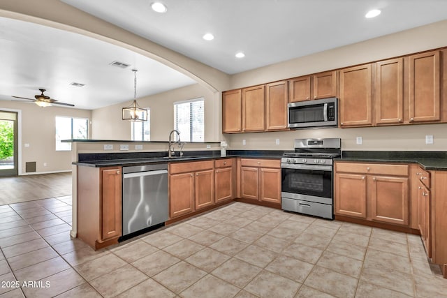209 E Diamond Trl, San Tan Valley, AZ 85143 - kitchen featuring stainless steel appliances, a sink, a peninsula, recessed lighting, and brown cabinetry
