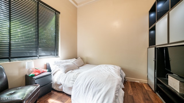 bedroom featuring dark hardwood / wood-style floors and ornamental molding