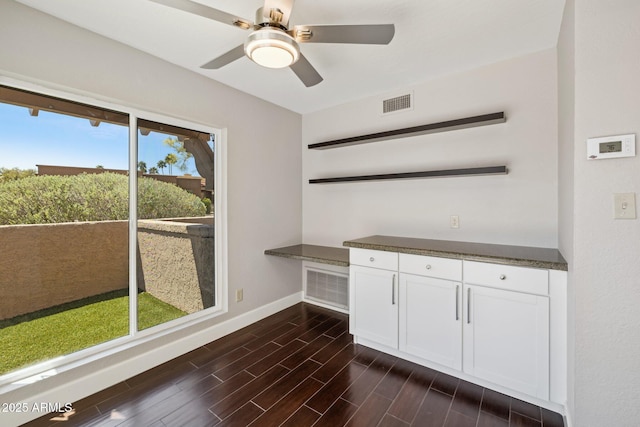 18548 E Parada Cir, Rio Verde, AZ 85263 - unfurnished dining area featuring ceiling fan, visible vents, baseboards, and dark wood finished floors