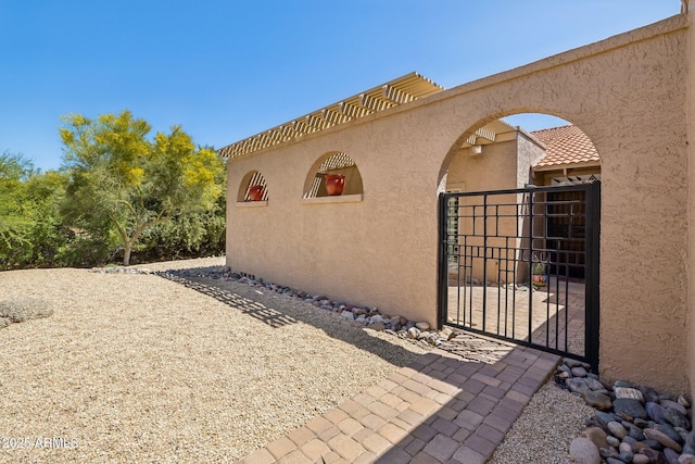 18548 E Parada Cir, Rio Verde, AZ 85263 - view of home's exterior featuring fence, stucco siding, and a gate