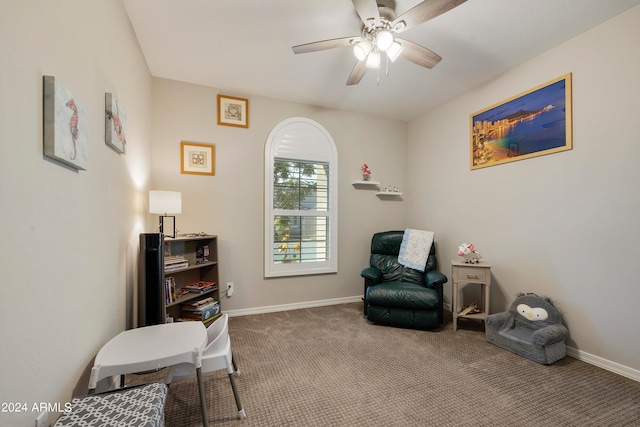 sitting room with ceiling fan and carpet