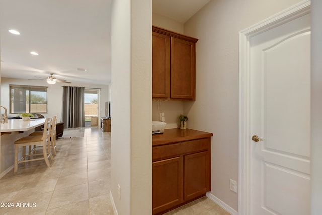 interior space featuring light tile patterned floors and ceiling fan