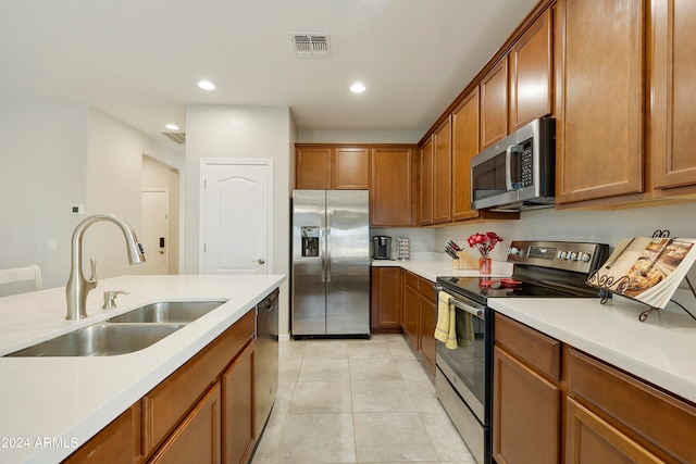 kitchen with light tile patterned floors, stainless steel appliances, and sink