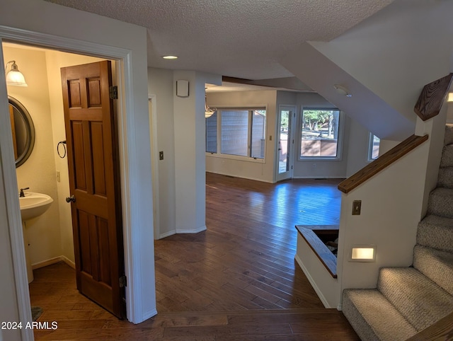 corridor with dark wood-type flooring and a textured ceiling